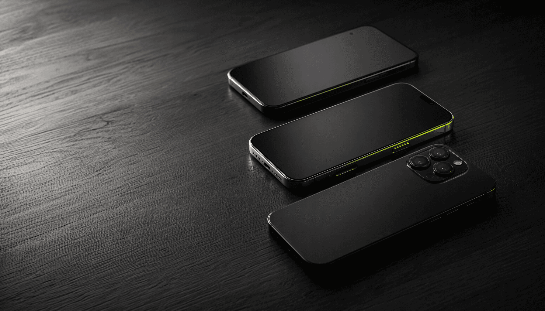 Three premium smartphones with titanium and matte black finishes arranged on a dark walnut desk